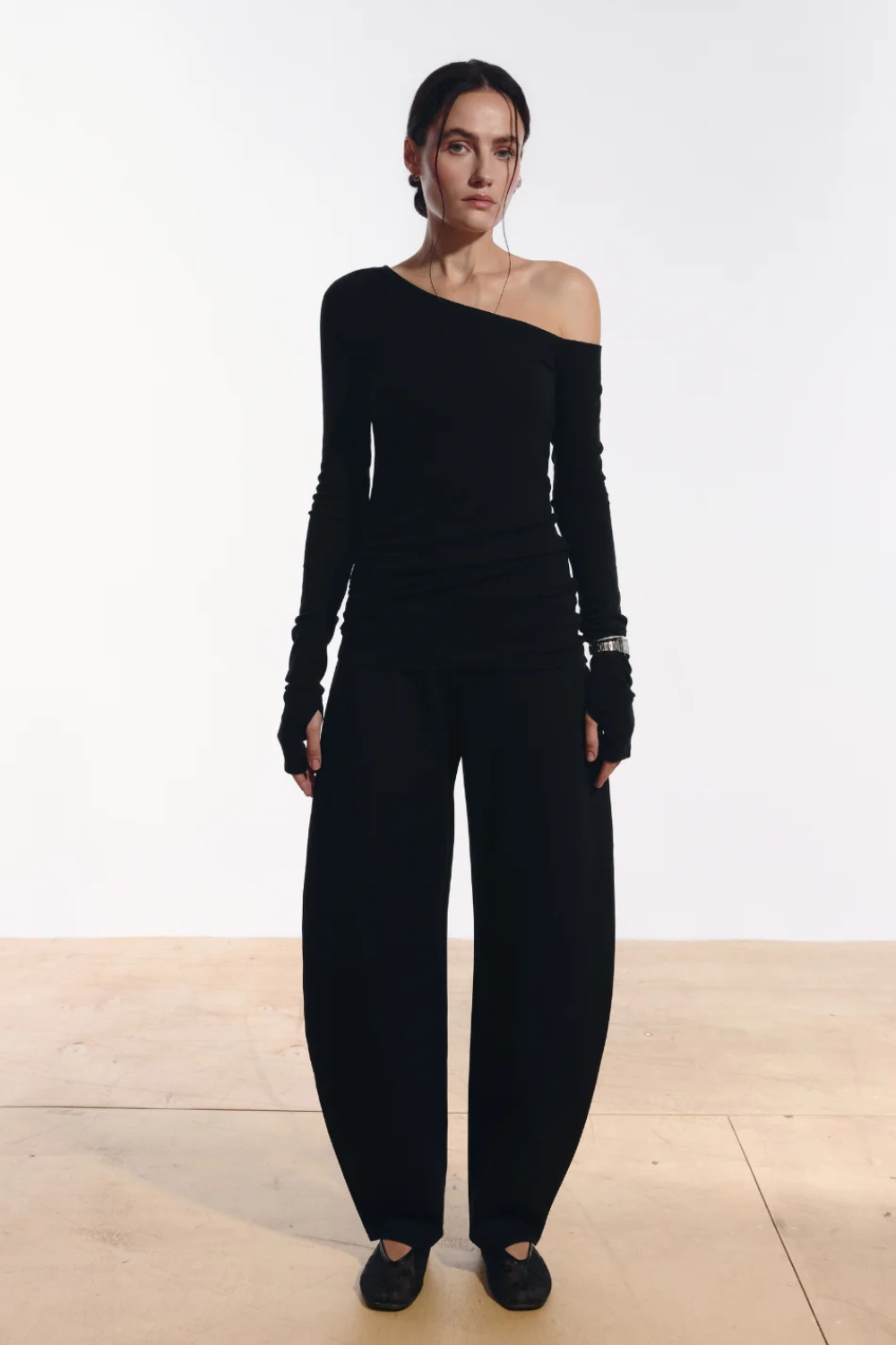 Ambitna one-shoulder top in black, front view of the asymmetric neckline. Independent Ukrainian designer at MIXMVSE London.