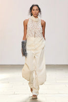 KARPOVA Semi-Sheer Turtleneck Top in white viscose. Front view of high-neck top with 3D hand-made appliqués. Independent Ukrainian designer at MIXMVSE London.