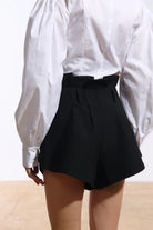 Ambitna mini shorts in black wool and silk, front view of the high-rise wide-leg cut. Independent Ukrainian designer at MIXMVSE London.