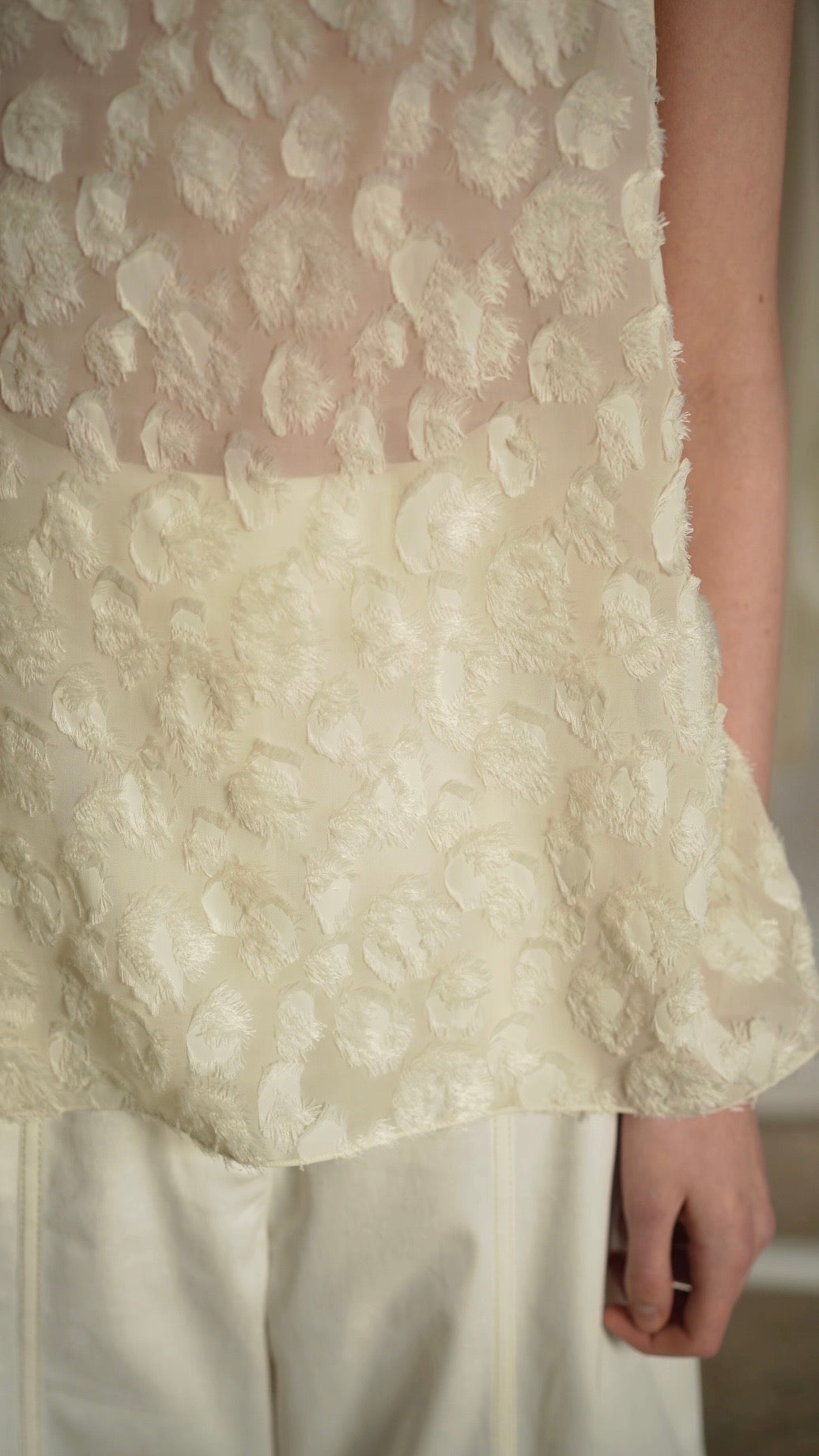 KARPOVA Semi-Sheer Turtleneck Top in white viscose. Close-up detail of 3D hand-made appliqués. Independent Ukrainian designer at MIXMVSE London.