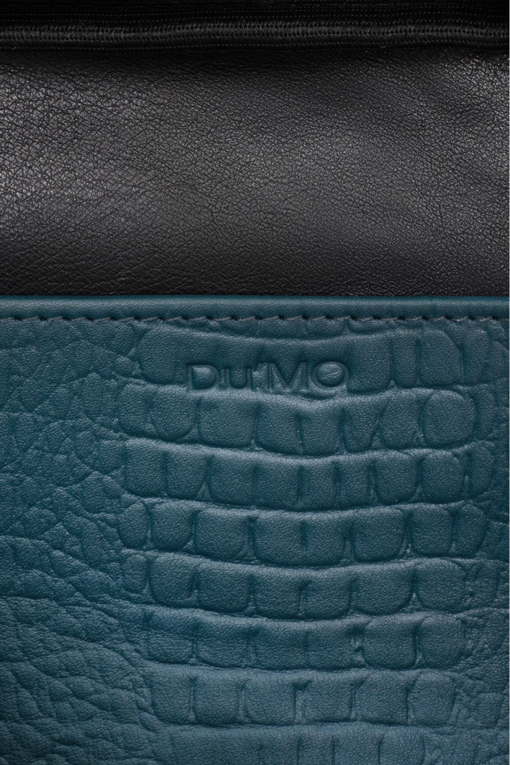Du'Mo Poise Small Bag detail of the debossed Du'Mo logo on sea wave crocodile-embossed leather. Independent Ukrainian designer at MIXMVSE London.