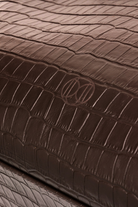 Du'Mo Portfolio Bag close-up of brown crocodile-embossed leather with debossed Du'Mo monogram. Independent Ukrainian designer at MIXMVSE London.