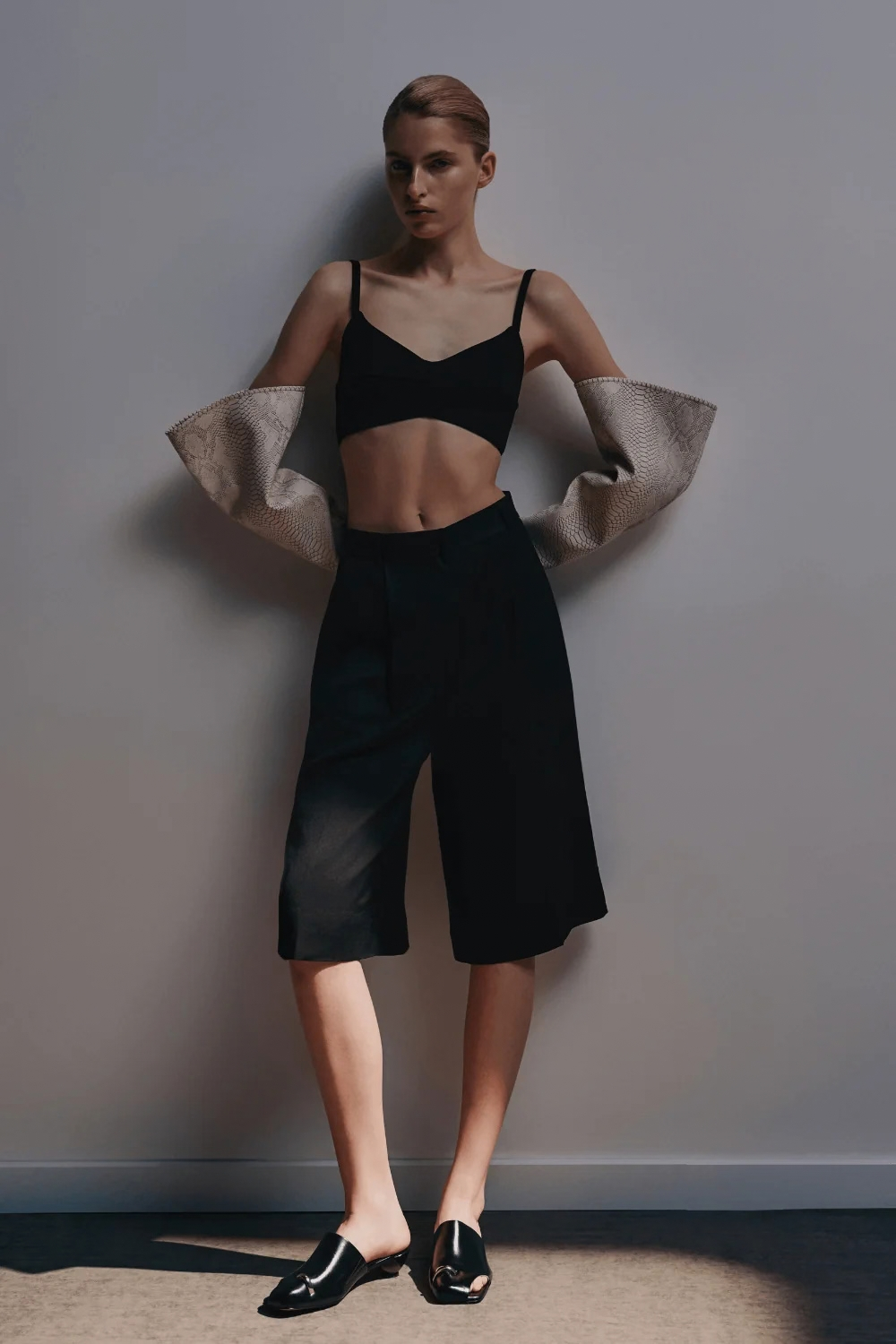 Ambitna black Bermuda shorts, knee-length tailored cut, styled look. Independent Ukrainian designer at MIXMVSE London.
