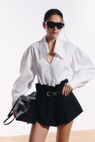 Ambitna white cotton shirt with wide sleeves styled with black wool mini shorts. Independent Ukrainian designer at MIXMVSE London.