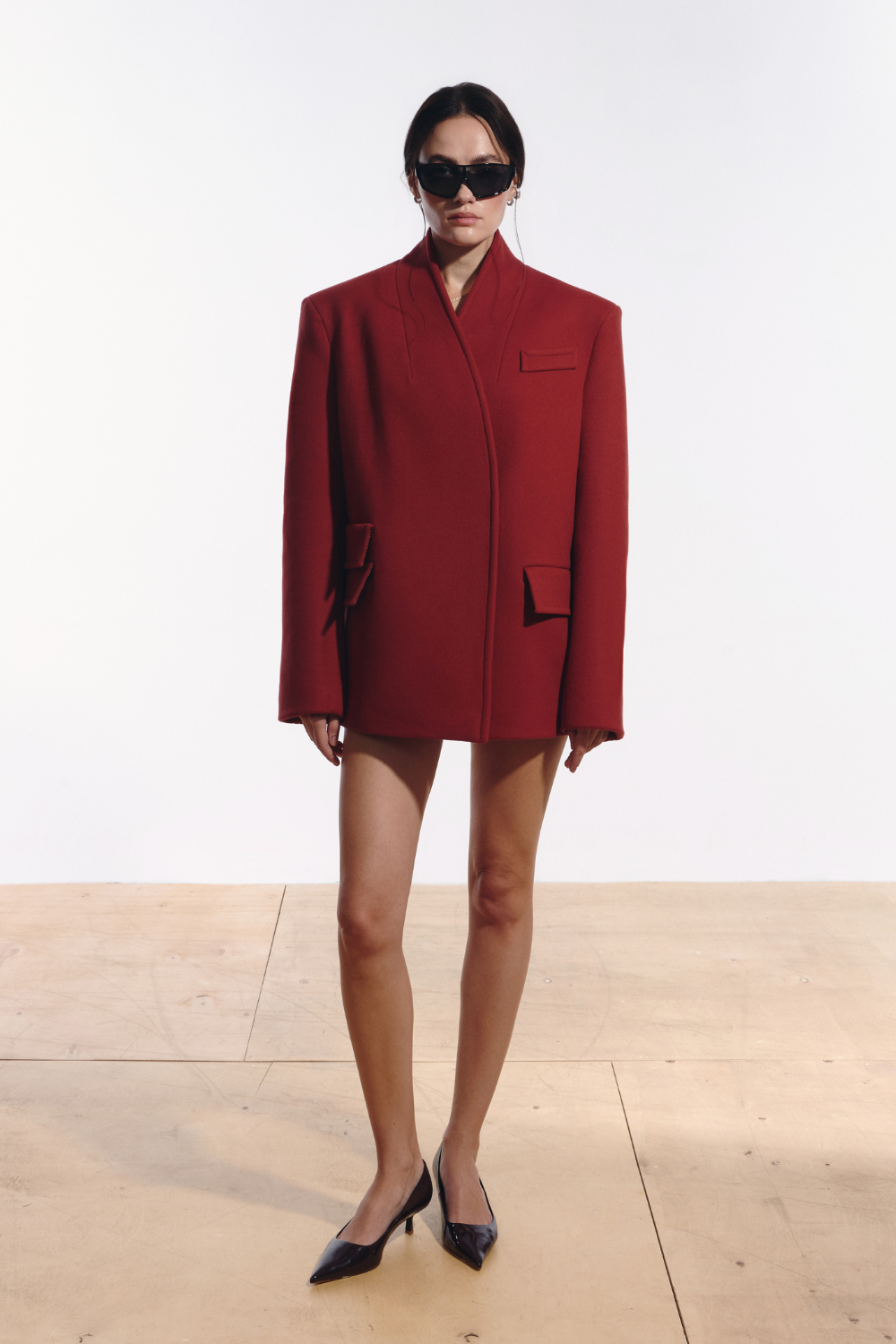 Ambitna red coat in wool and cashmere, front view of the longline silhouette with V-line neckline. Independent Ukrainian designer at MIXMVSE London.