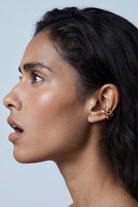 Chuk gold Spiral ear cuff worn on the ear. Ukrainian designer jewellery at MIXMVSE London.